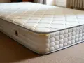 Matelas usagé, taché, avec des signes de dégradation. Le polyuréthane peut présenter un danger s'il est mal ventilé ou décomposé.