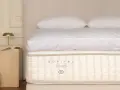 Un matelas Sofitel My Bed, symbole d'un choix literie de luxe, avec des draps blancs et des oreillers moelleux.