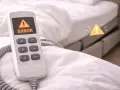 Télécommande d'un lit électrique affichant "ERROR". Un symbole d'alerte jaune est superposé. Cela peut affecter la durée de vie d'un lit électrique.