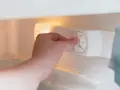 Main tenant ajuste la molette pour régler la quelle temperature congelateur. Le bouton indique "STOP" et des chiffres de 0 à 7.