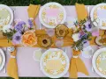 Jolie table de Pâques avec des lapins en papier, des fleurs fraîches et des œufs décorés. Une belle idée déco table Pâques pour un repas printanier.