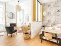 Une belle idée séparation chambre salon avec un mur décoré de nuages et un coin salon cosy.