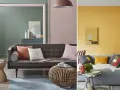 Canapé gris avec coussins aux couleurs variées, dont un coussin corail et un blanc cassé. Ambiance cosy et moderne.