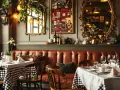Ambiance chaleureuse d'un déco bistrot parisien avec banquette en cuir, tables dressées et miroirs dorés.