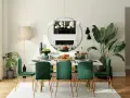 Une arche élégante sépare le salon de la salle à manger, révélant une table dressée avec des chaises en velours vert émeraude.