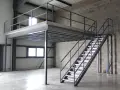 Escalier métallique menant à une création mezzanine dans un entrepôt. Structure industrielle fonctionnelle.