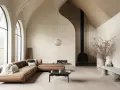 Un **salon cathédrale** aux lignes épurées, avec un canapé en cuir marron, une cheminée noire suspendue et de grandes fenêtres cintrées.
