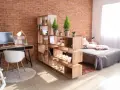 Étagère modulable en bois pour séparer une pièce en deux sans travaux, créant un espace bureau et un coin nuit.