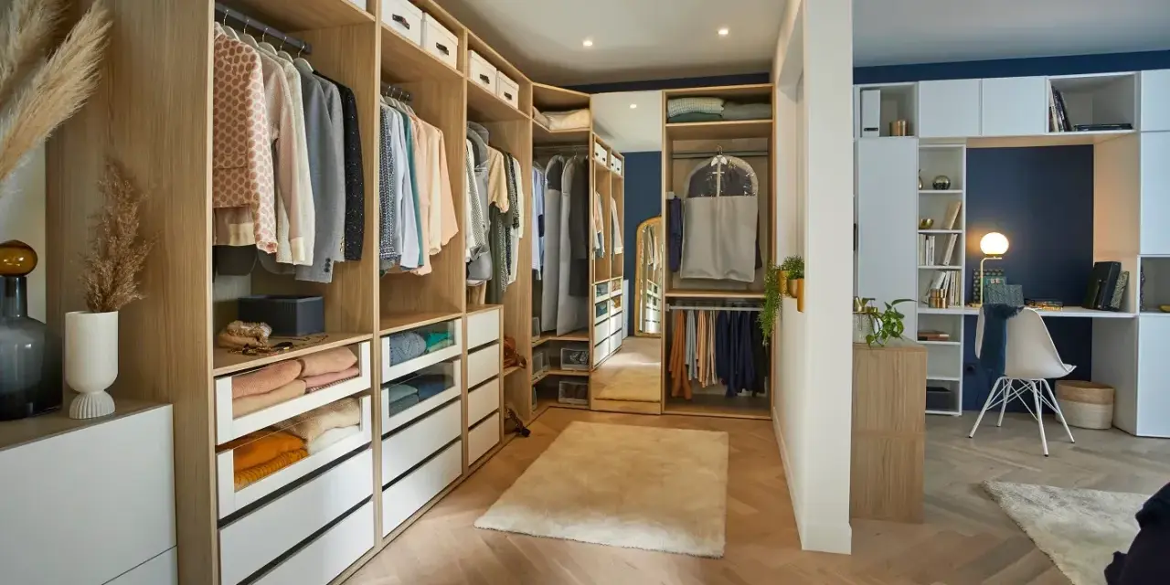 Un dressing DIY bien organisé avec des étagères en bois, des tiroirs blancs et des vêtements suspendus. Un espace fonctionnel pour ranger vos affaires.