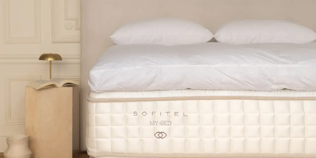 Un matelas Sofitel My Bed, symbole d'un choix literie de luxe, avec des draps blancs et des oreillers moelleux.