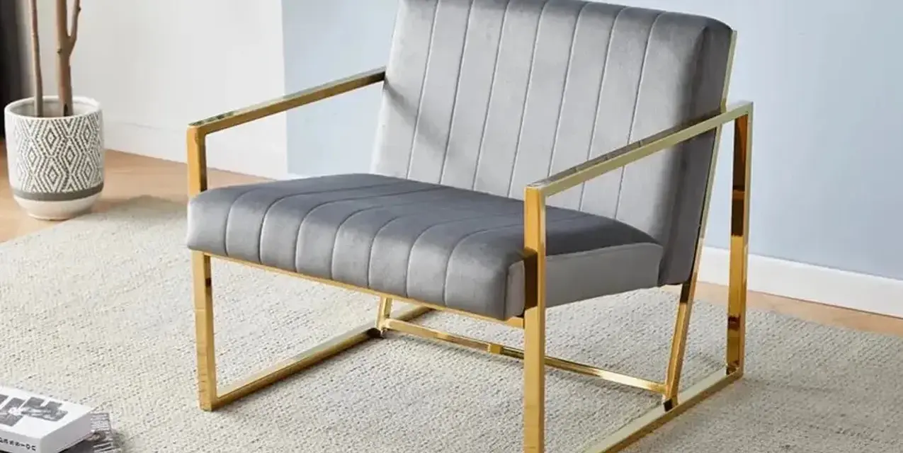 Fauteuil moderne gris velours avec structure dorée, un exemple élégant parmi les différents types de fauteuils pour un salon chic.