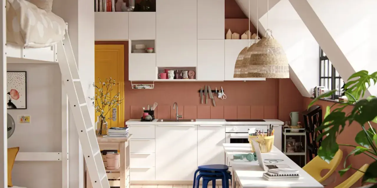 Aménager un studio : lit mezzanine, cuisine blanche, porte jaune, et coin bureau fonctionnel sous les combles.