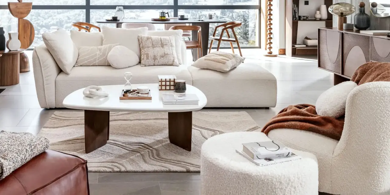 Un confortable salon d'hiver avec un canapé moelleux, une table basse design et une vue panoramique sur les montagnes enneigées.