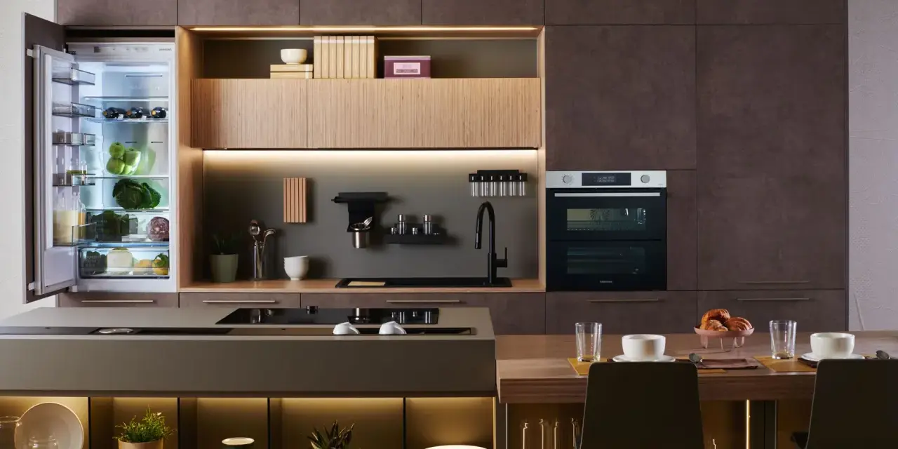 Cuisine moderne avec réfrigérateur ouvert, montrant des aliments frais. Le réfrigérateur est de taille frigo standard, intégré dans des meubles élégants.