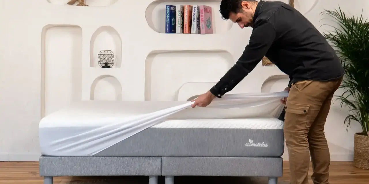 Un homme installe une housse sur un matelas, assurant ainsi sa protection.