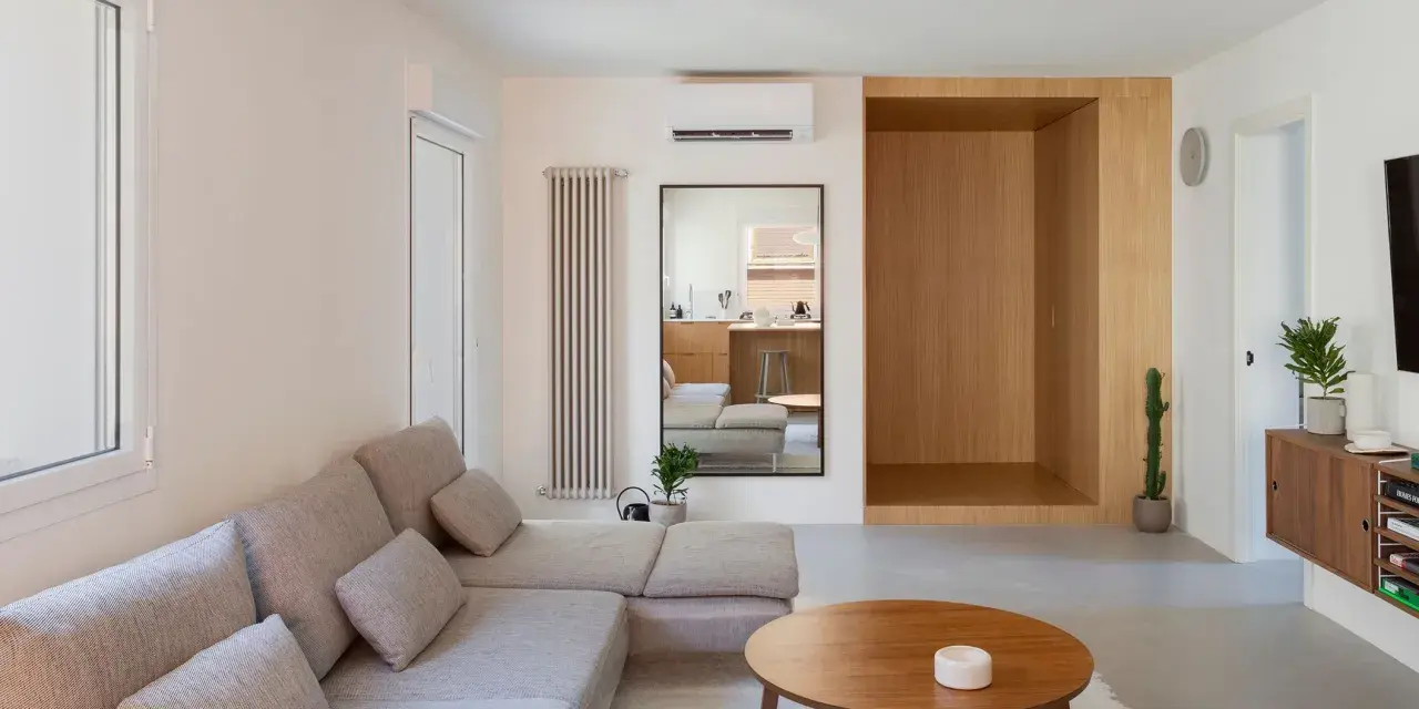 Salon épuré avec canapé modulable, table basse en bois et un coin boisé rappelant une maison style japonais en France.