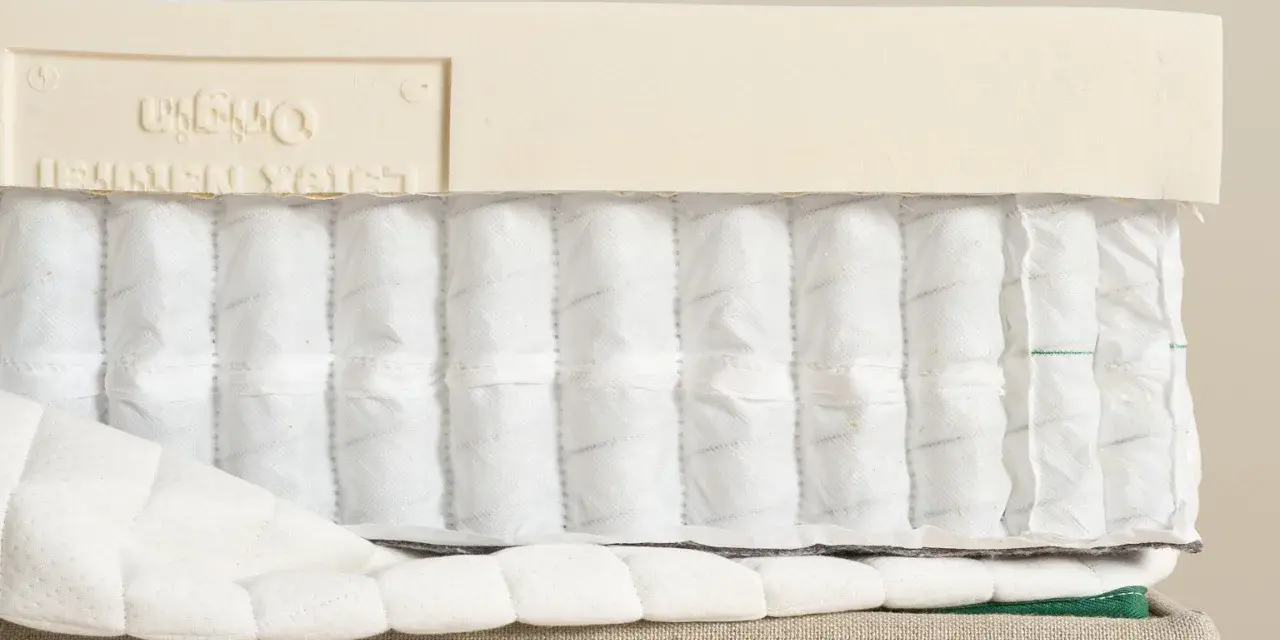 Coupe d'un matelas montrant les ressorts ensachés et la couche de latex. Comprendre la structure aide à savoir pourquoi mon matelas neuf se creuse.