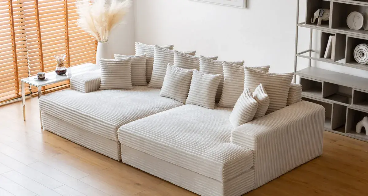 Canapé modulable blanc côtelé, parfait pour un salon cosy. Sa faible hauteur le rend idéal pour un espace moderne.
