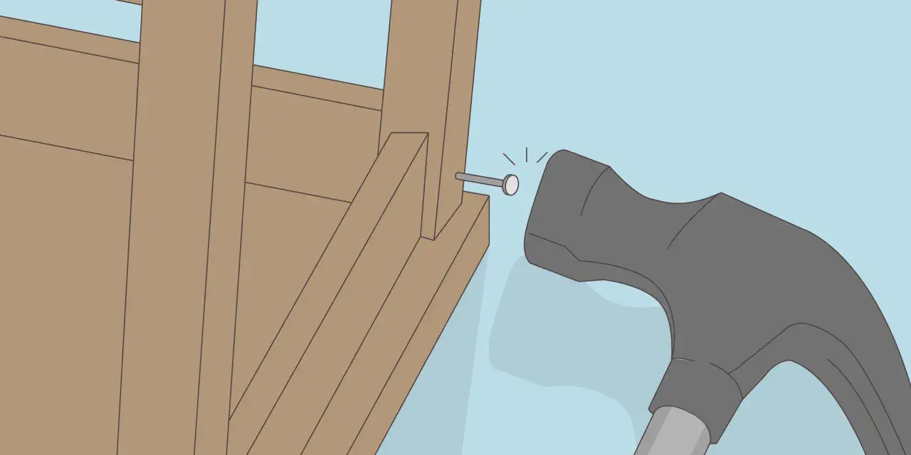 Un marteau s'apprête à frapper un clou dans la structure en bois d'un fauteuil qui grince.