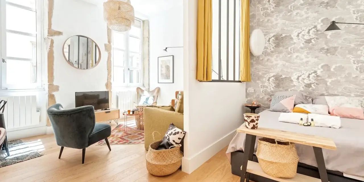 Une belle idée séparation chambre salon avec un mur décoré de nuages et un coin salon cosy.