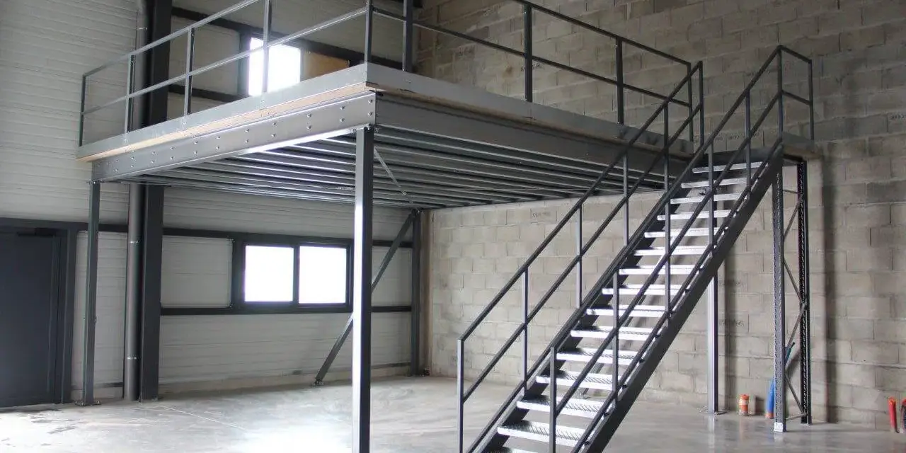 Escalier métallique menant à une création mezzanine dans un entrepôt. Structure industrielle fonctionnelle.