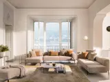 Un salon cocooning chaleureux avec un grand canapé d'angle, des coussins douillets et une vue imprenable sur un lac.