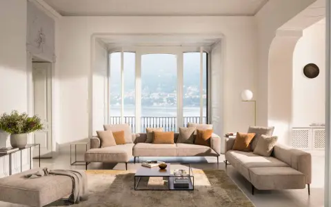 Un salon cocooning chaleureux avec un grand canapé d'angle, des coussins douillets et une vue imprenable sur un lac.