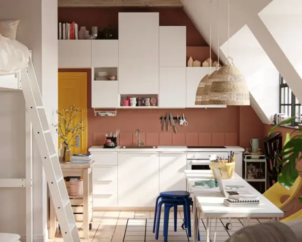 Aménager un studio : lit mezzanine, cuisine blanche, porte jaune, et coin bureau fonctionnel sous les combles.