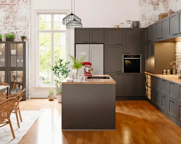 Cuisine moderne avec îlot central et armoires sombres. Un réfrigérateur non encastrable est discrètement intégré dans le décor.