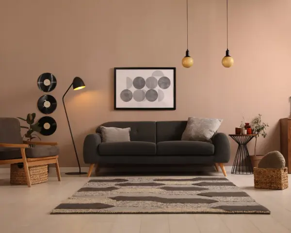 Idée déco salon avec canapé noir : ambiance cosy avec vinyles vintage, tapis graphique et fauteuil en bois.
