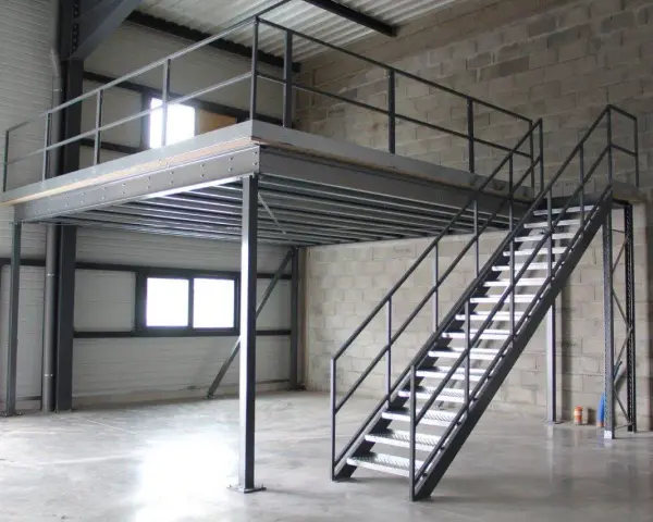Escalier métallique menant à une création mezzanine dans un entrepôt. Structure industrielle fonctionnelle.