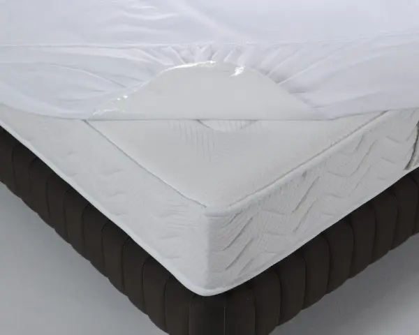 Un matelas blanc avec une alèse imperméable soulevée, montrant de quel côté mettre une alèse pour protéger le matelas.
