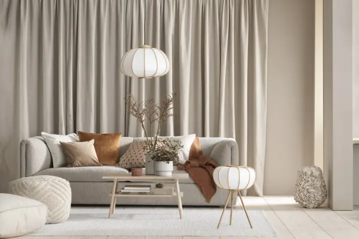 Quelle deco avec canapé gris clair : coussins texturés, plaid ocre, table basse en bois, lampes douces. Ambiance cosy et naturelle.