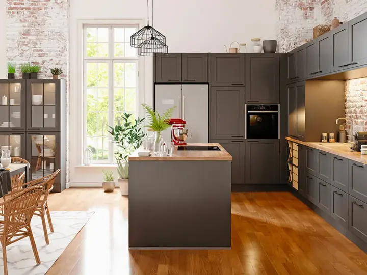 Cuisine moderne avec îlot central et armoires sombres. Un réfrigérateur non encastrable est discrètement intégré dans le décor.