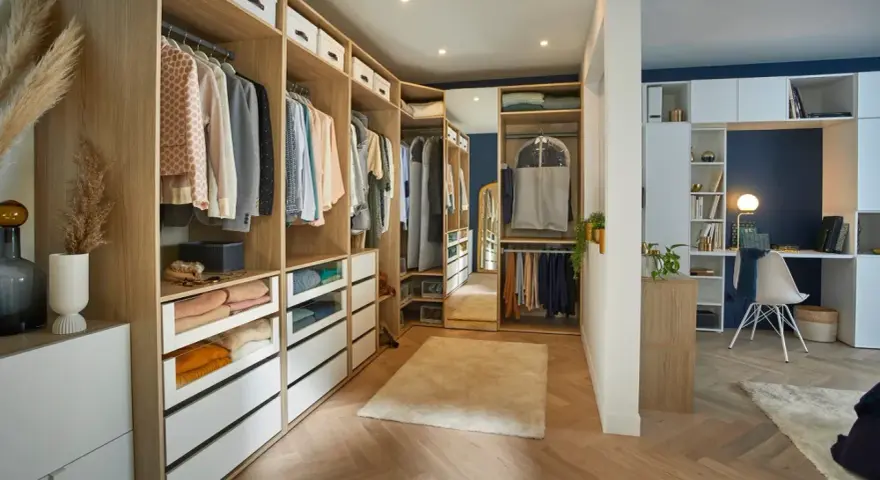 Un dressing DIY bien organisé avec des étagères en bois, des tiroirs blancs et des vêtements suspendus. Un espace fonctionnel pour ranger vos affaires.