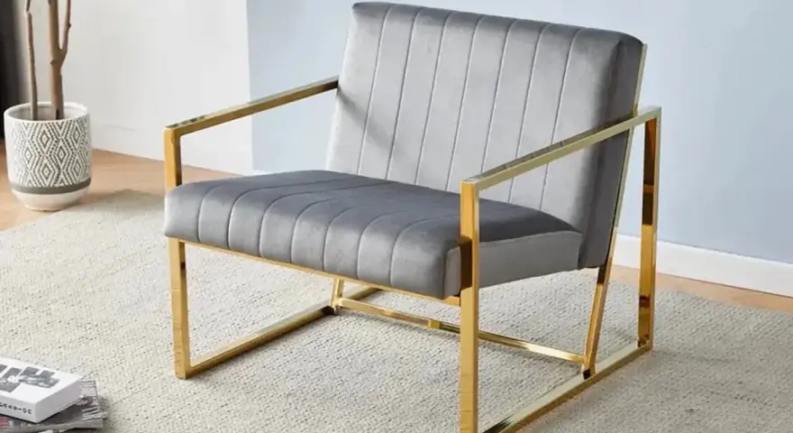 Fauteuil moderne gris velours avec structure dorée, un exemple élégant parmi les différents types de fauteuils pour un salon chic.