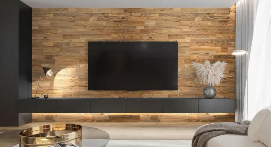 Un salon moderne avec un mur en bois chaleureux servant de **déco derrière télé**. Un meuble bas suspendu et une lampe design complètent l'ensemble.