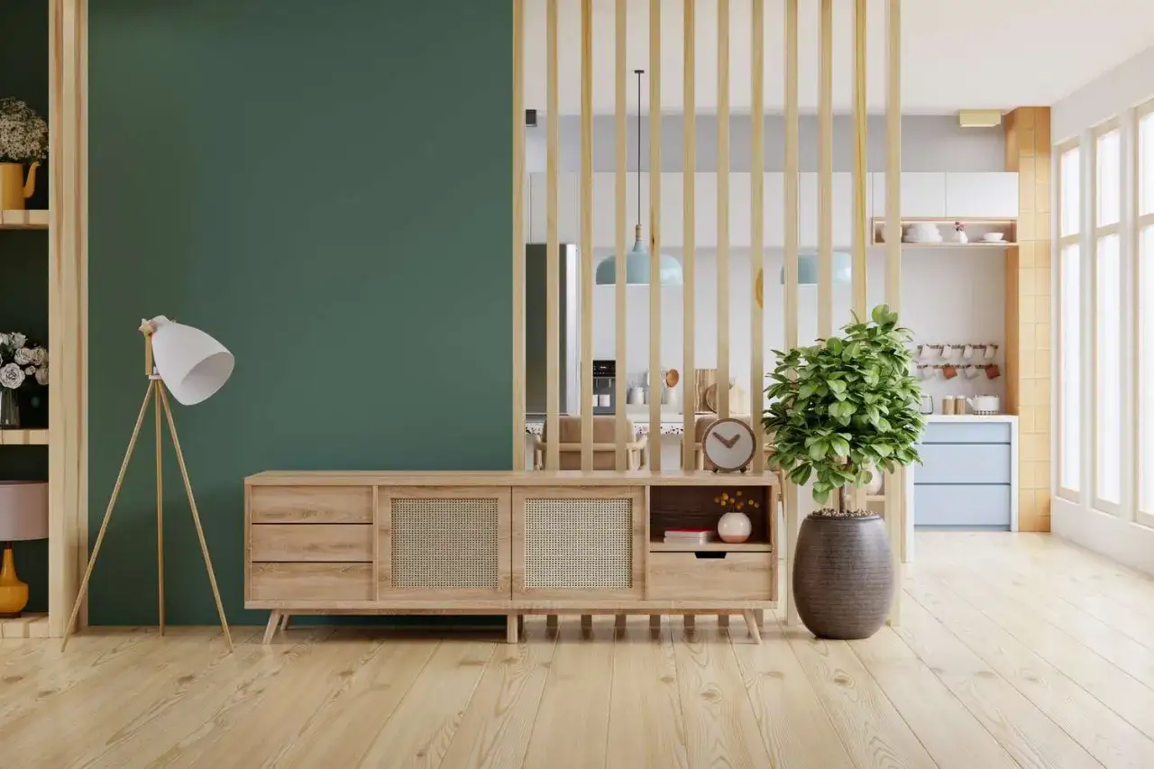 Un paravent en bois s&eacute;pare &eacute;l&eacute;gamment une pi&egrave;ce en deux sans travaux. Un buffet bas en bois clair, une plante verte et une lampe compl&egrave;tent l'ensemble.