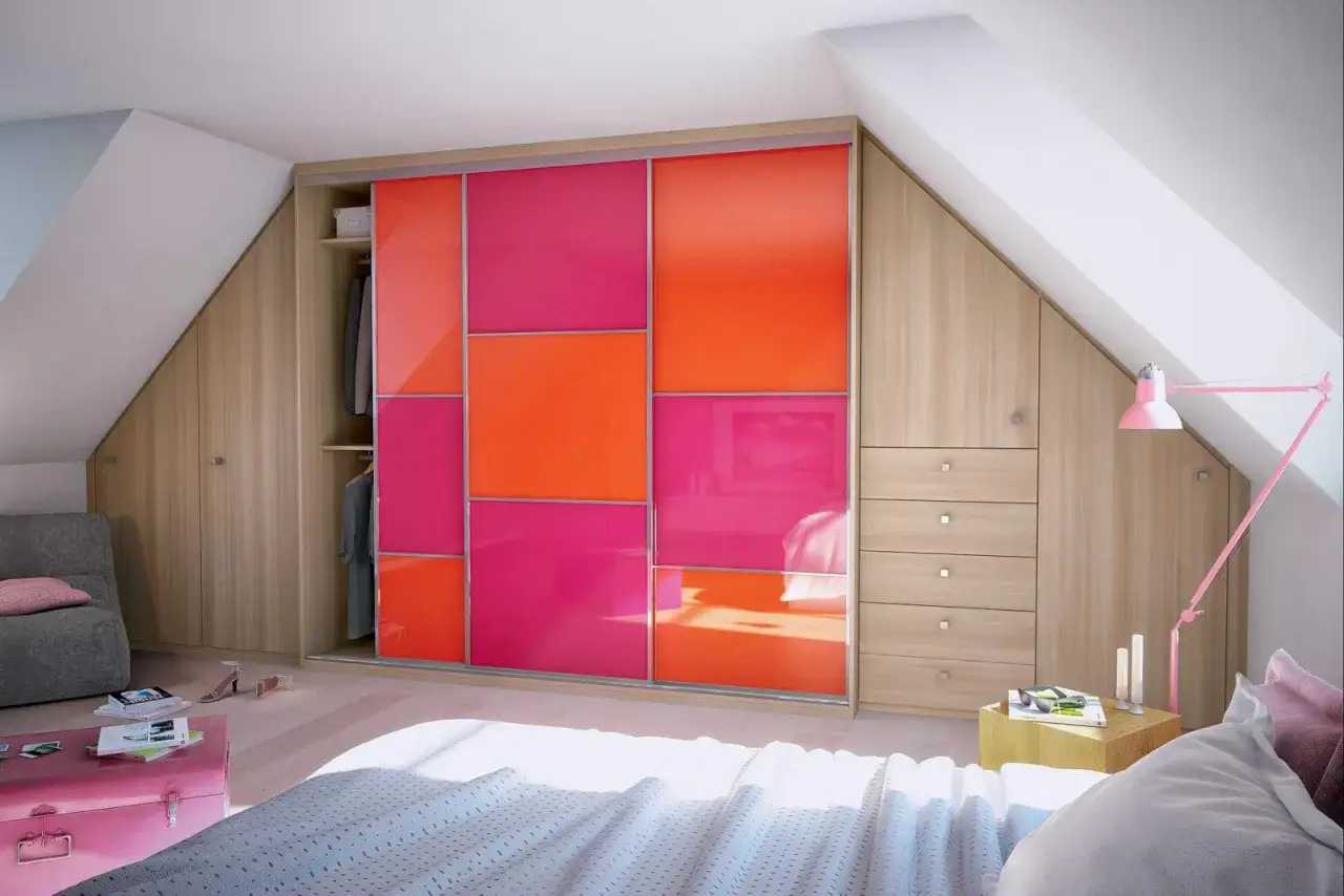 Armoire dressing DIY aux portes coulissantes color&eacute;es rose et orange, int&eacute;gr&eacute;e dans une chambre mansard&eacute;e.
