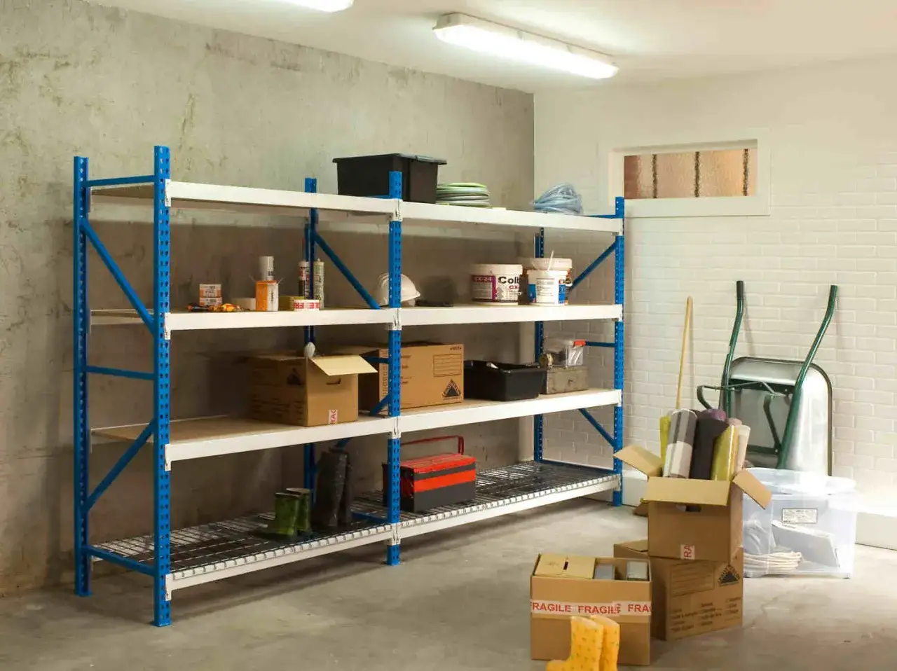 Étagères bleues et blanches remplies d'articles divers, offrant une excellente idée d'aménagement de cave pour un rangement optimal.