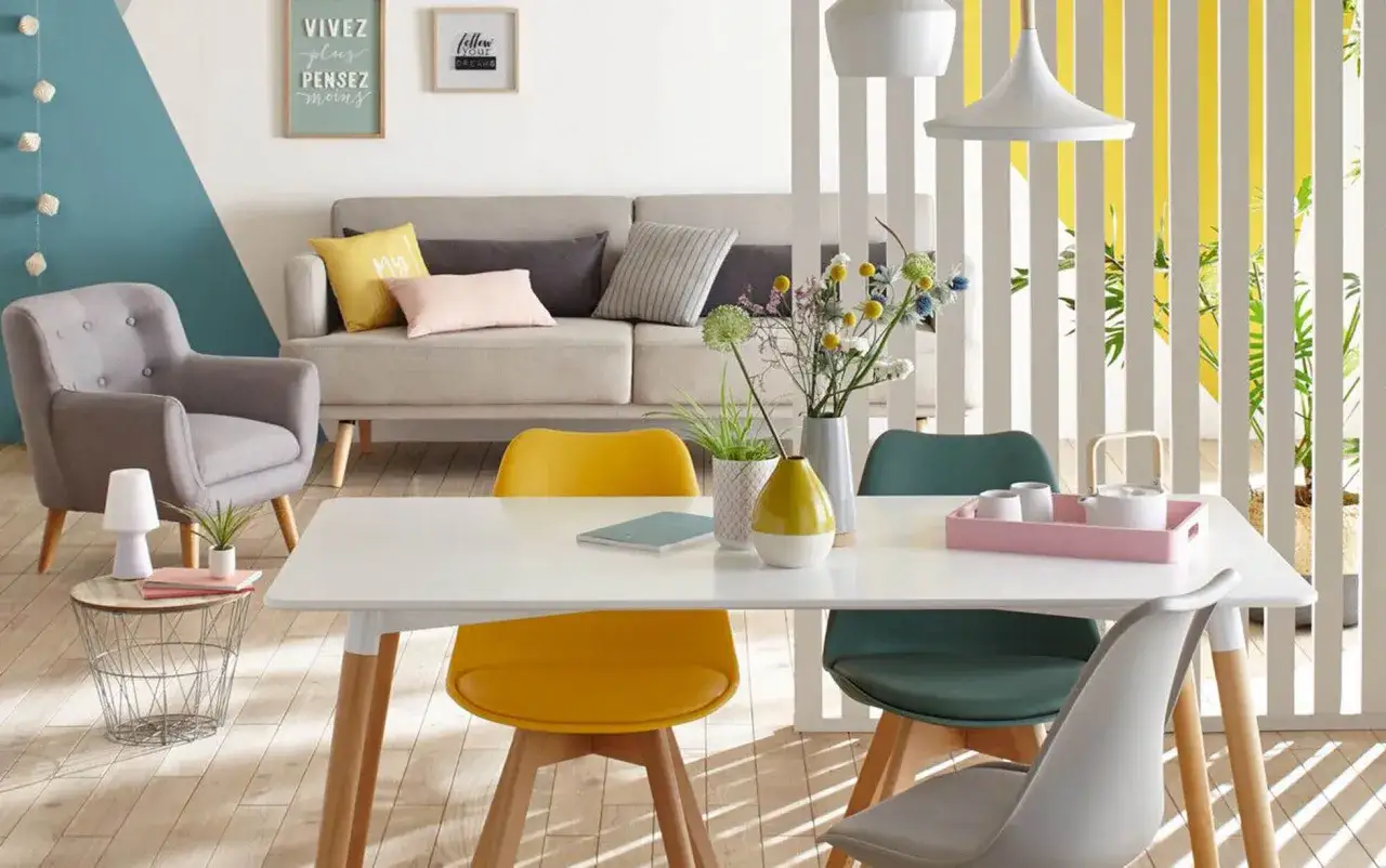 Un salon salle &agrave; manger 12m2 lumineux avec canap&eacute;, fauteuil, table et chaises color&eacute;es.