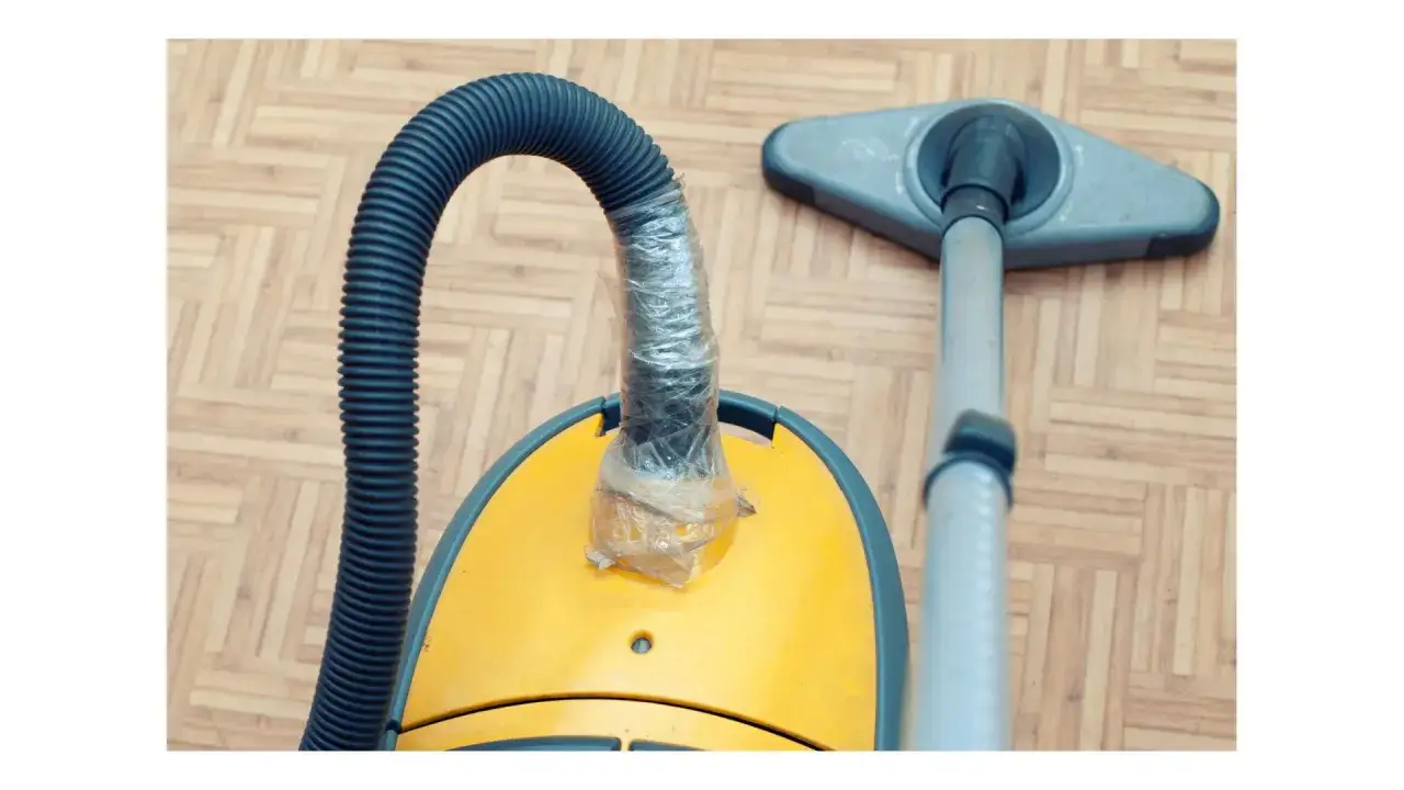 Le tuyau de mon aspirateur Rowenta, rafistol&eacute; avec du film plastique, ne fonctionne plus. La brosse est pos&eacute;e sur le parquet.