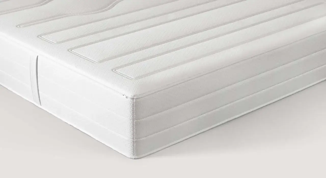 Un matelas blanc aux lignes matelass&eacute;es, dont la mati&egrave;re latex offre un confort optimal pour un sommeil r&eacute;parateur.