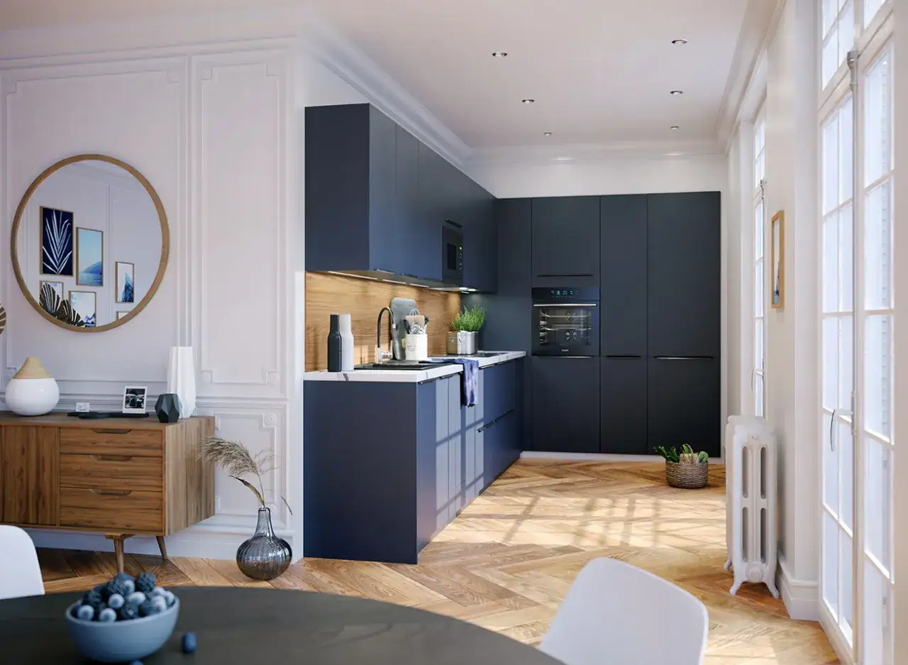 Cuisine moderne avec armoires bleues fonc&eacute;es, un &icirc;lot central et un four encastr&eacute;. L'astuce pour cacher un frigo non encastrable est de l'int&eacute;grer dans les meubles.