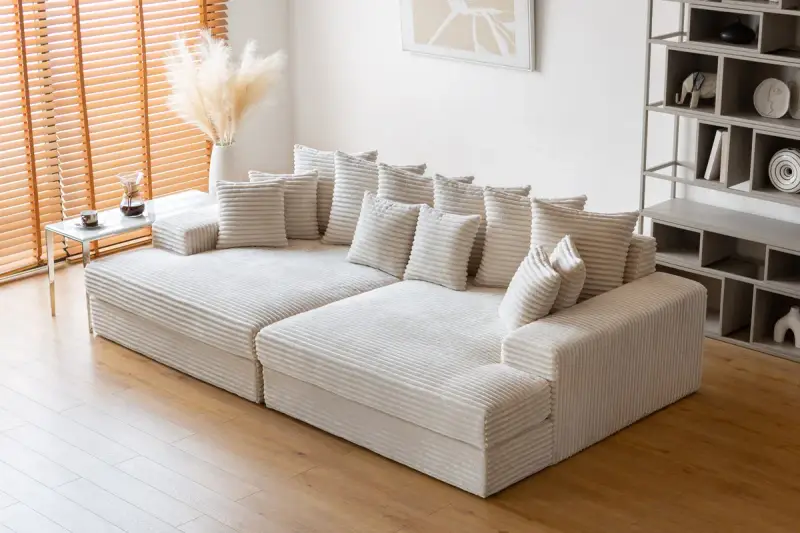 Canapé modulable blanc côtelé, parfait pour un salon cosy. Sa faible hauteur le rend idéal pour un espace moderne.