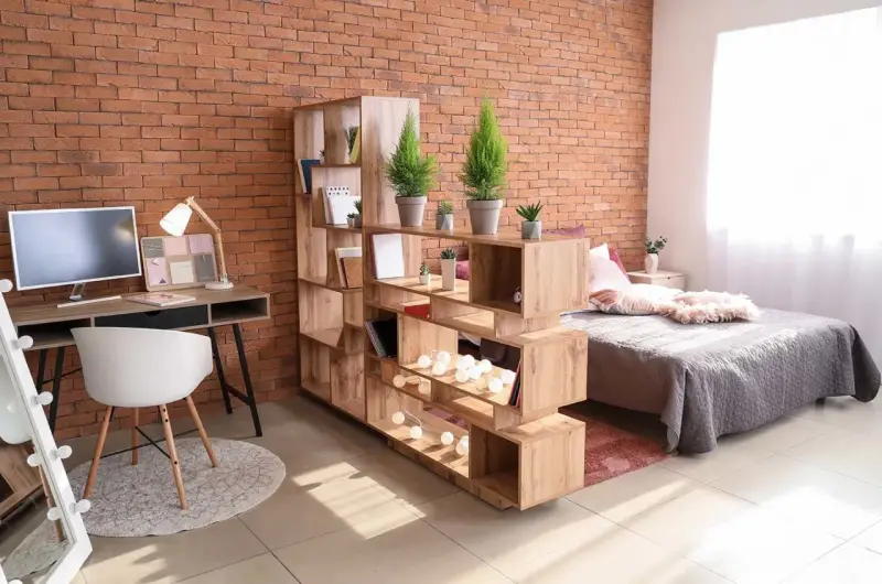 Étagère modulable en bois pour séparer une pièce en deux sans travaux, créant un espace bureau et un coin nuit.